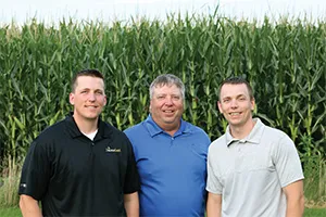 Three men standing at corn farm