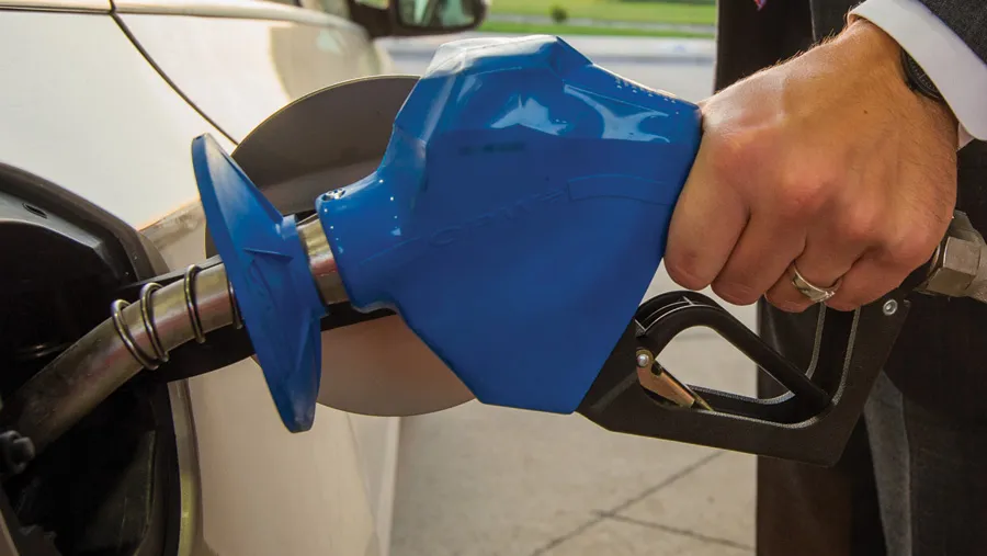A hand refueling a car