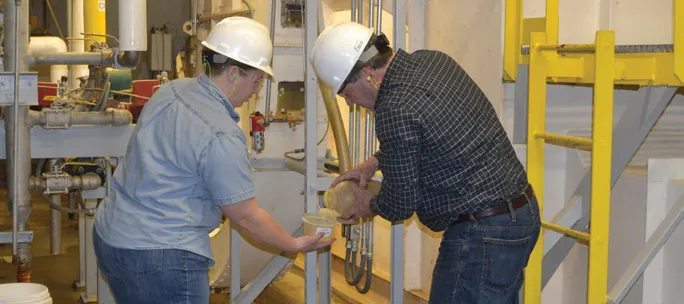 Sen. Joe Donnelly works alongside a POET team member at POET Biorefining
