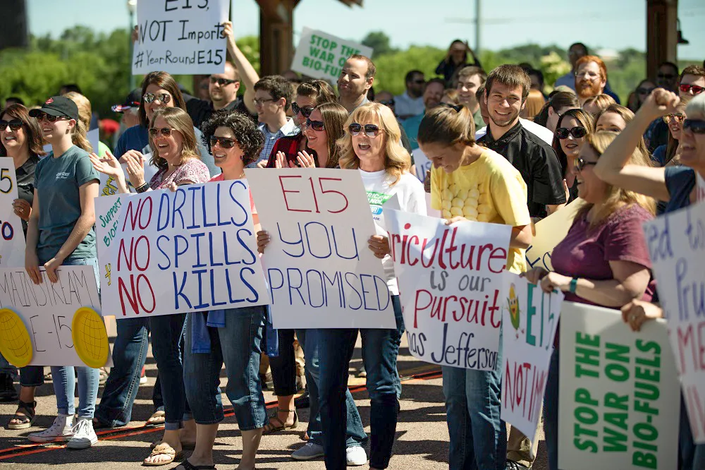 Protesters holding signs at outdoor rally
