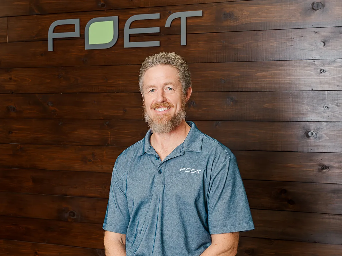 Hanson standing in front of wall with PET logo on the wall