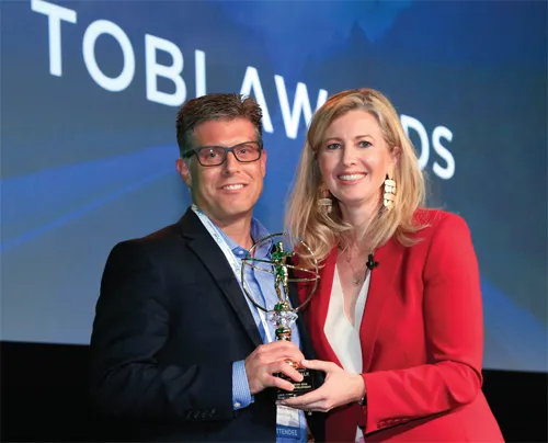 A mand and a woman holding an award