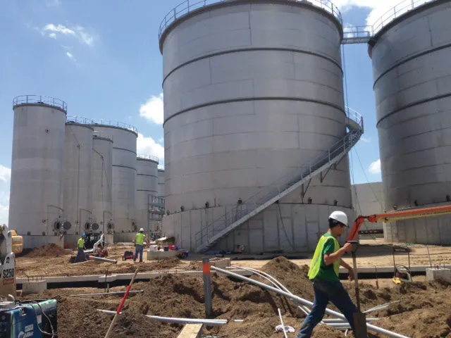 Infrastructure being installed underground in preparation for concrete floors. Conversion tanks in the background.