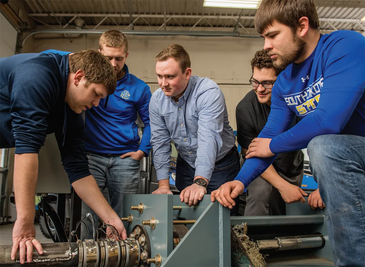 Engineering students discuss the project with POET engineer