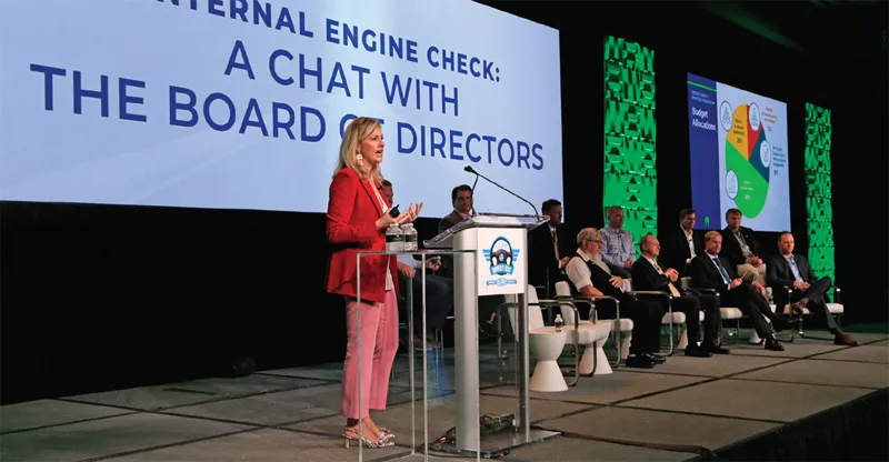 A woman in suit speaks at podium on stage