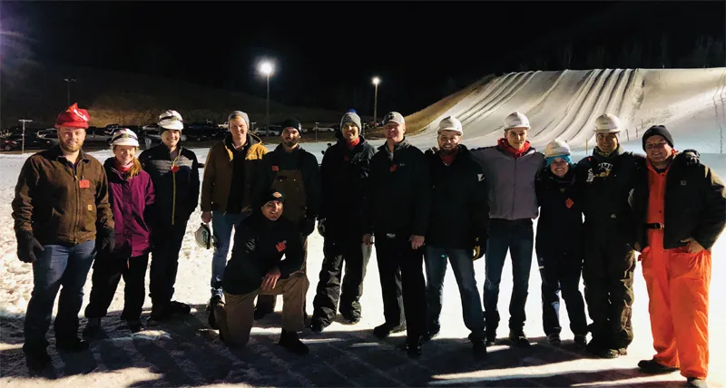 A group of people wearing hard hats taking a picture outside