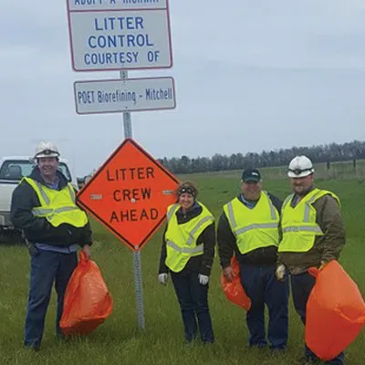 Four people standing by the Litter Crew Ahead sign