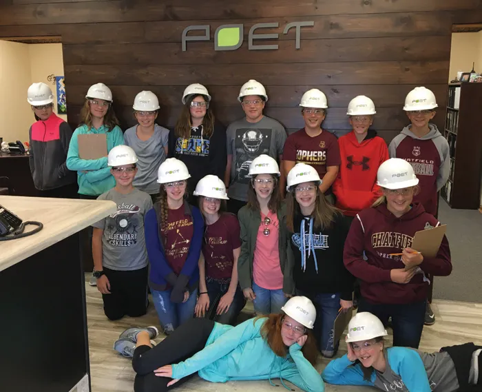 A group of science students wearing hard hats taking a picture