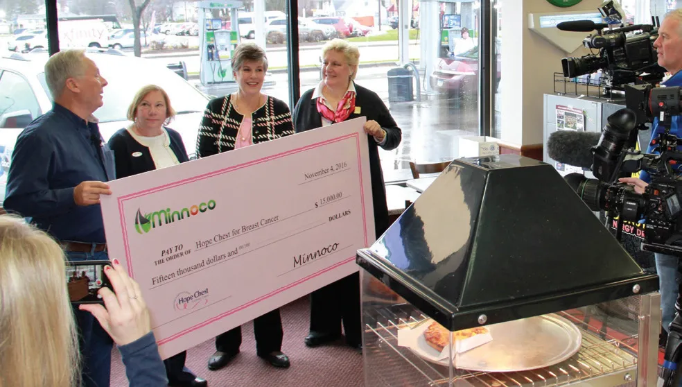 Four people holding a big cheque