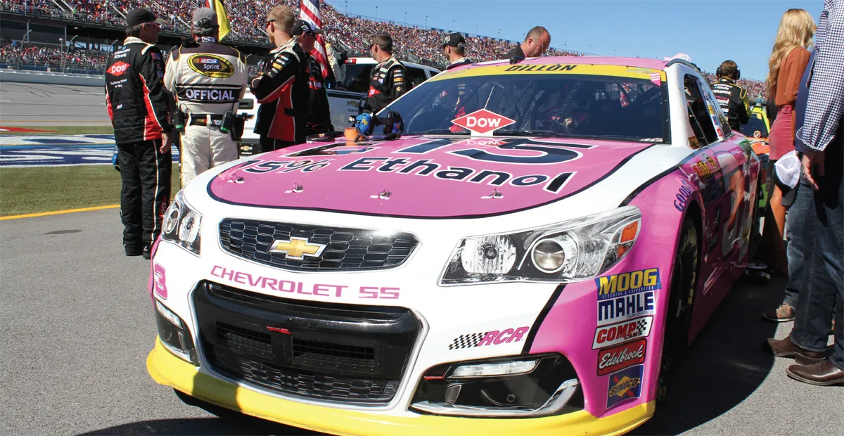 A pink race car and people around it