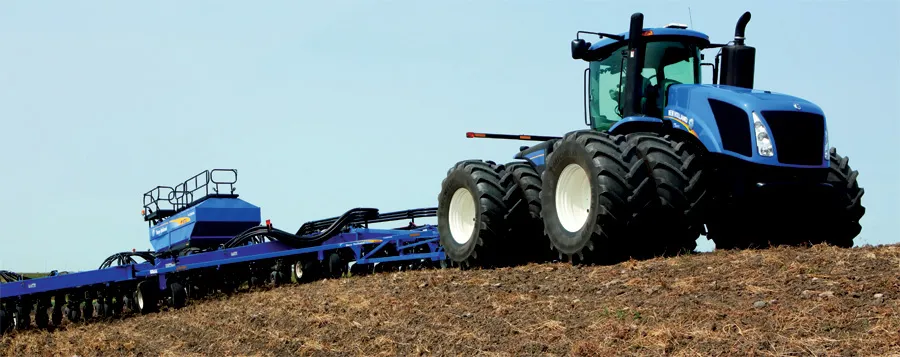 Blue tractor with planter on a hillside