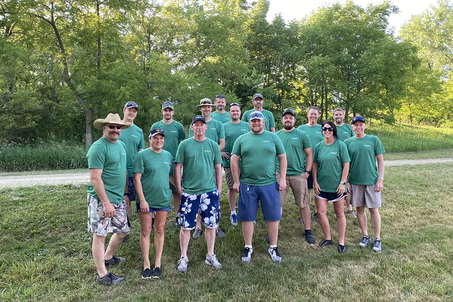 A group in green shirts posing outdoors