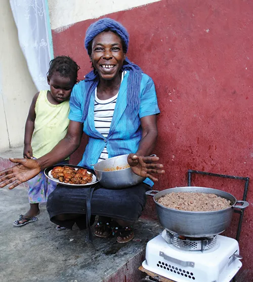 A woman cooking while a kid standing next to her