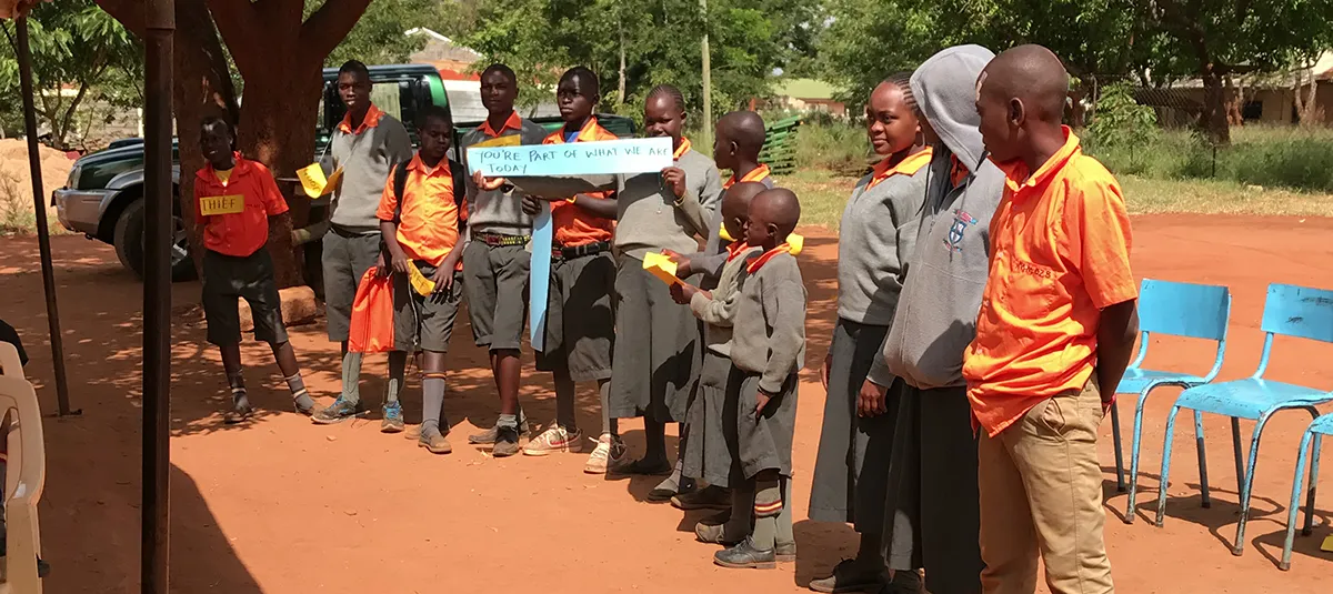 Students in orange uniforms are lined up outdoors