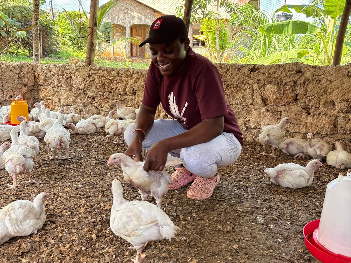 Mercy Saumu Mwango works with the chickens on her farm