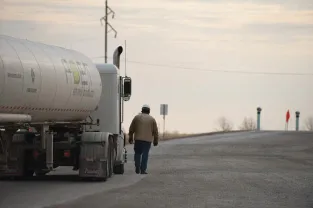 A man standing next to a truck on the road
