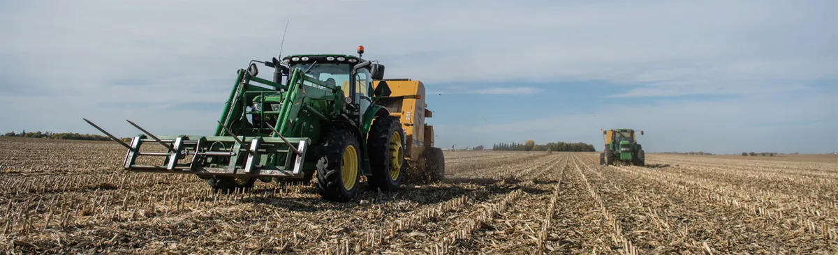 Two tractors working in harvested field