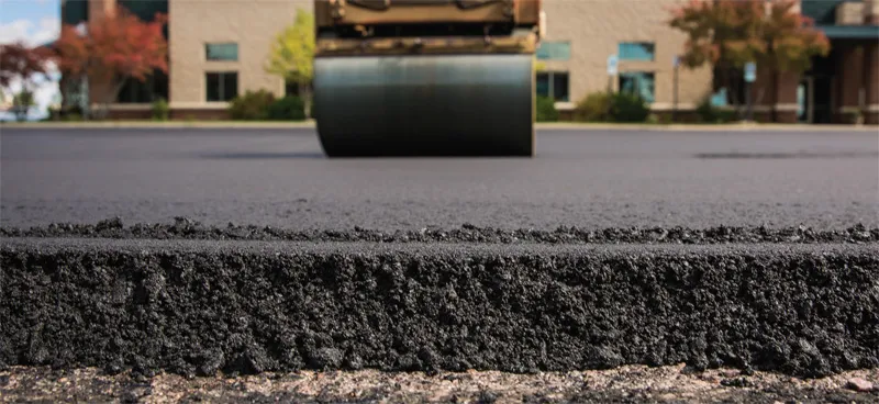 Road roller compacting fresh asphalt