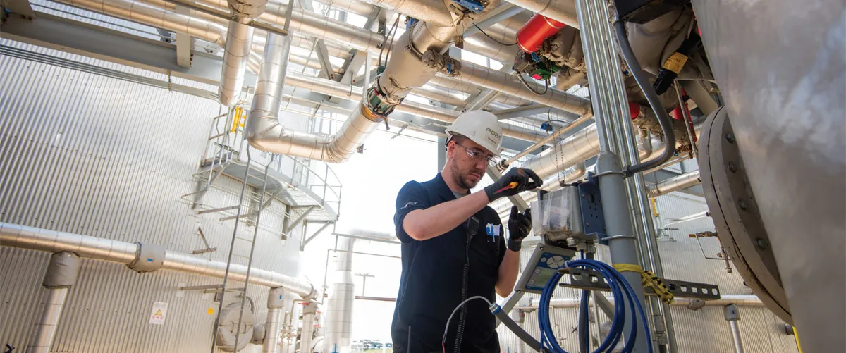 Maintenance technician inspecting industrial pipes