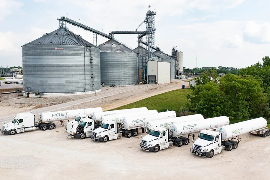 Grain silos and row of tanker trucks