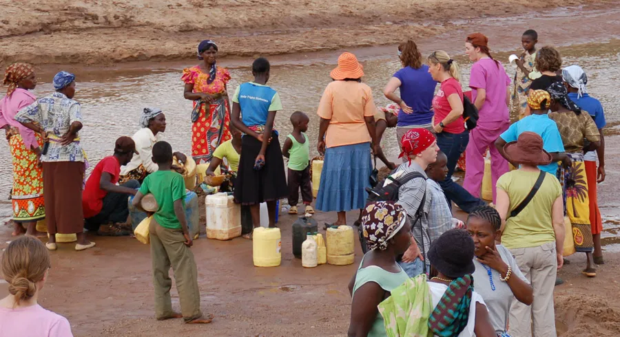 Group of people around water containers