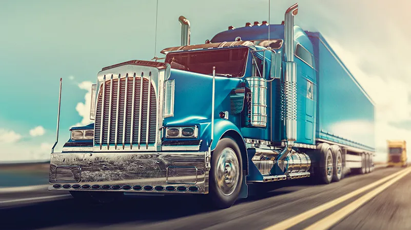 Blue semi-truck driving on highway