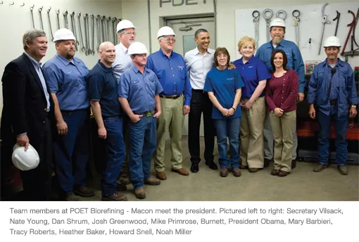 Group of workers in hard hats posing in workshop
