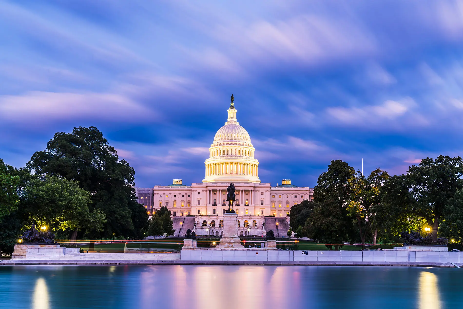 View of the illuminated United States Capitol building at dusk.