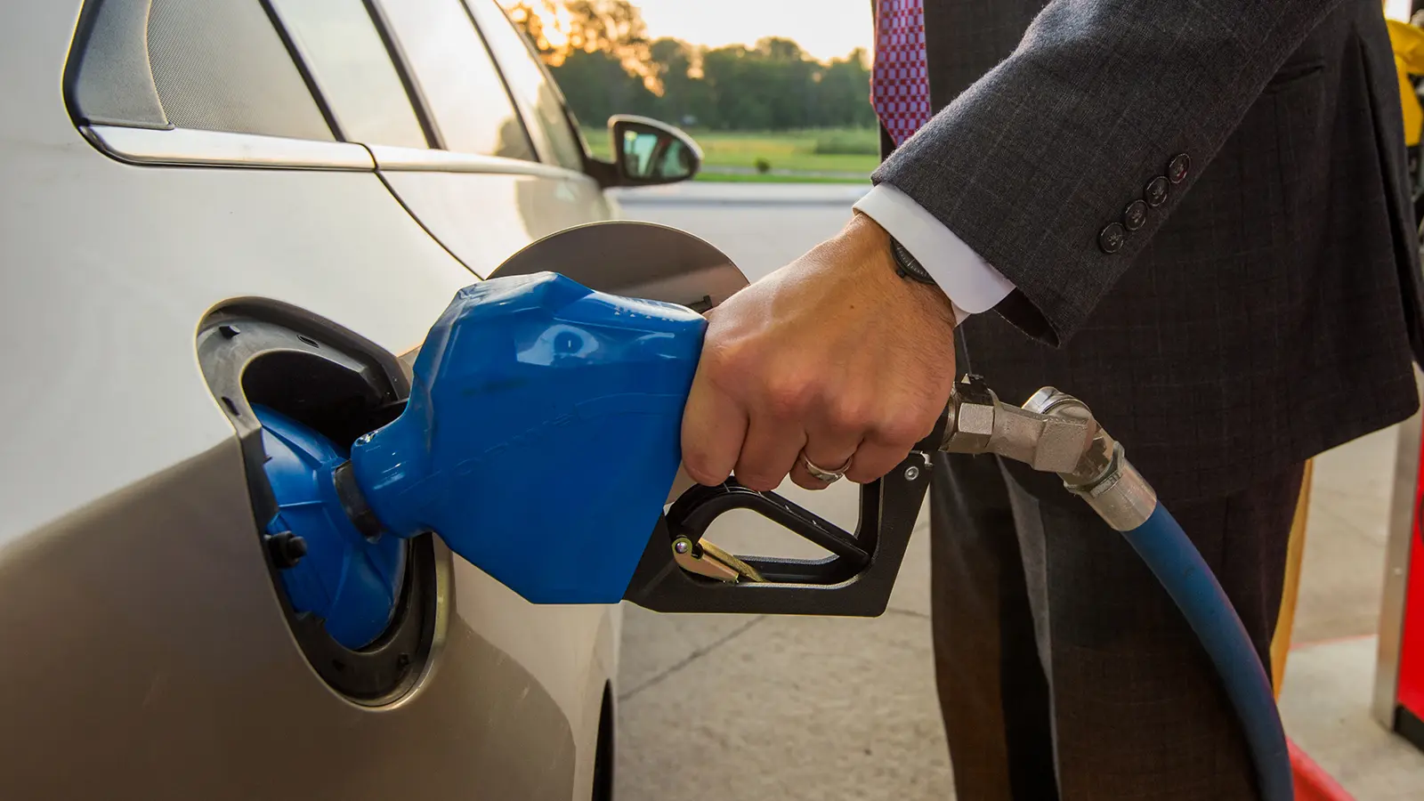Man in suit pumping gas