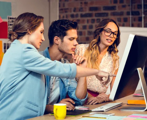 A group of people looking at a computer screen.