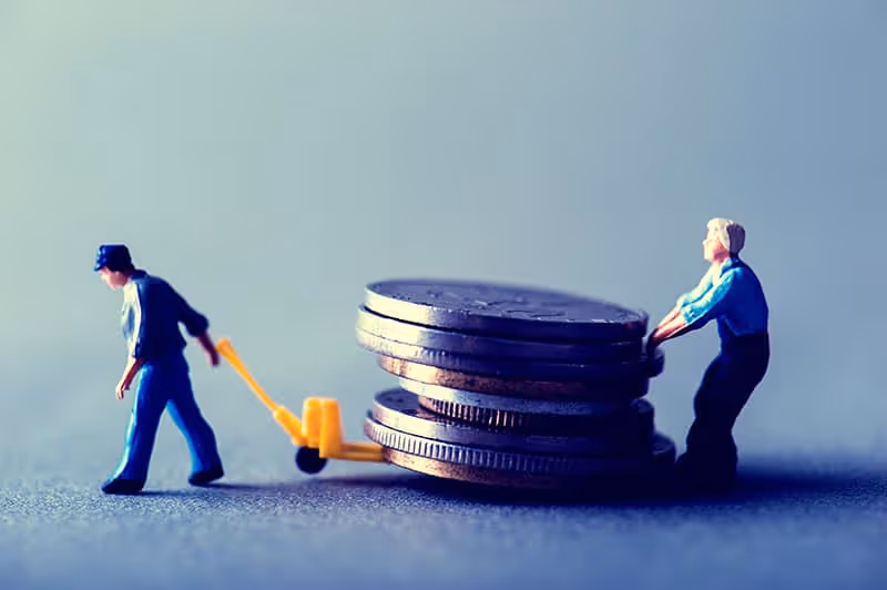 Small figurines of people pushing coins