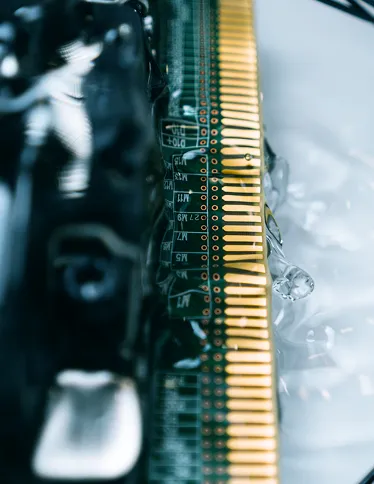 Close-up of a computer memory module's gold connector pins and circuit board.