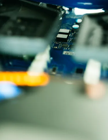 Blurred close-up of a blue computer circuit board with electronic components.