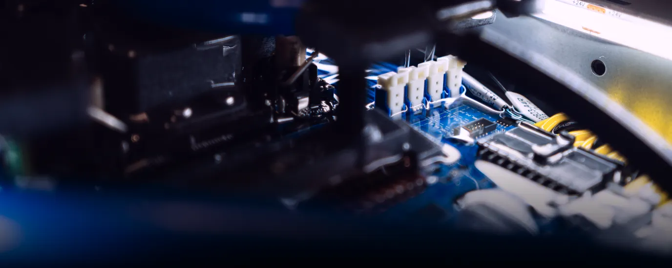 Close-up of electronic circuit board with connectors, chips, and cables inside a device.
