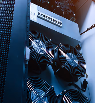 Close-up of a server rack with four cooling fans and an Ethernet switch panel above them.