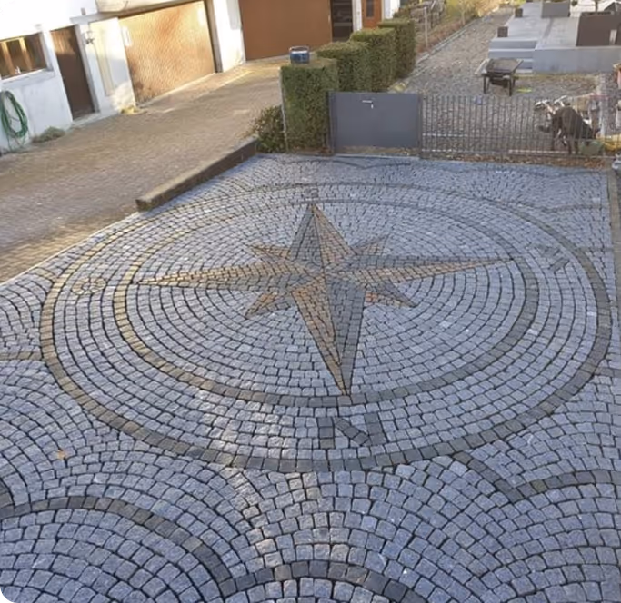Große Steinpflasterfläche mit einer eingelassenen Windrose aus verschiedenfarbigen Steinen.
