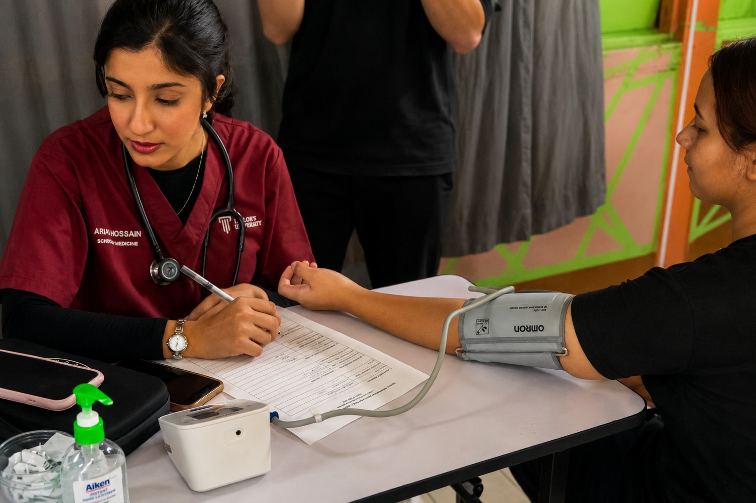 Healthcare volunteer measuring a participant's blood pressure during a community health awareness programme.