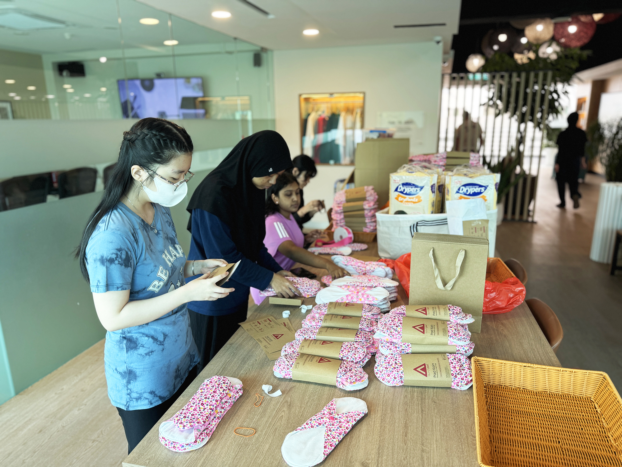 LaunchPad committees assembling reusable cloth pad care packs in preparation for community distribution.