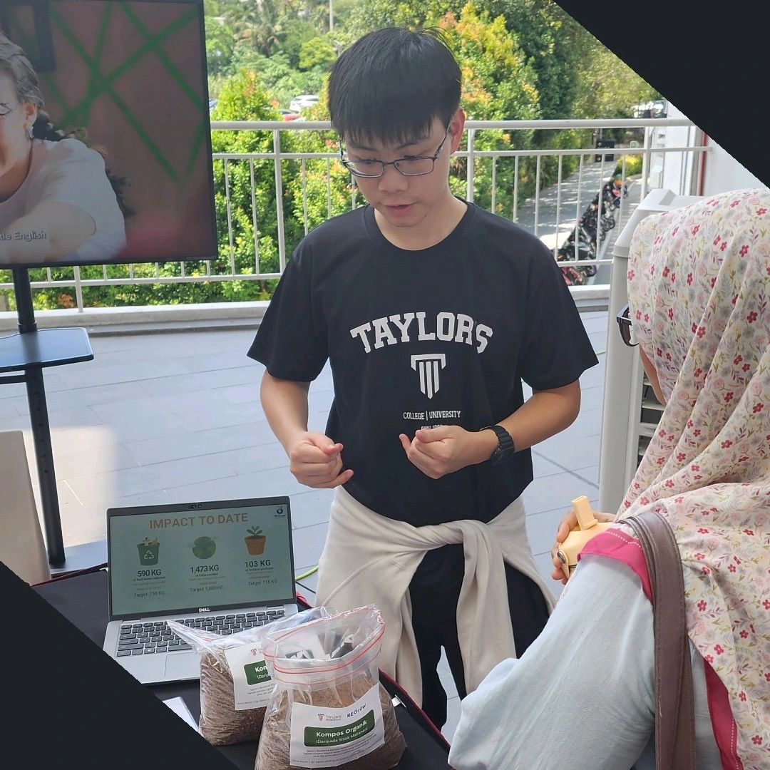 Student volunteer introducing REGrow and its sustainable food waste management initiative to a visitor.