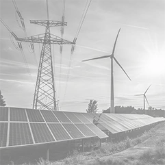 Solar panels, wind turbines, and an electrical transmission tower under the sun in a grassy field.