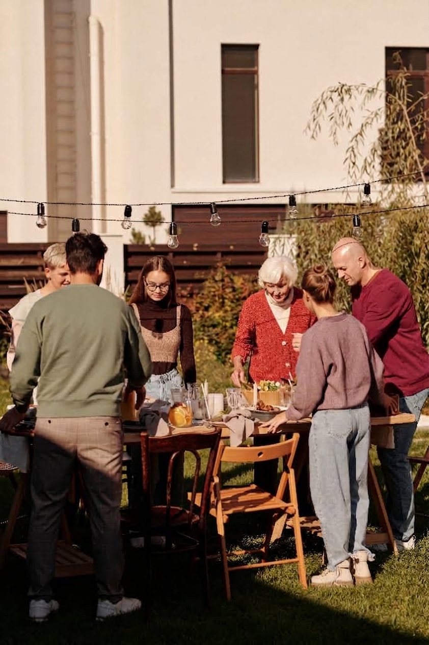 Three generations of a family setting a table in the garden