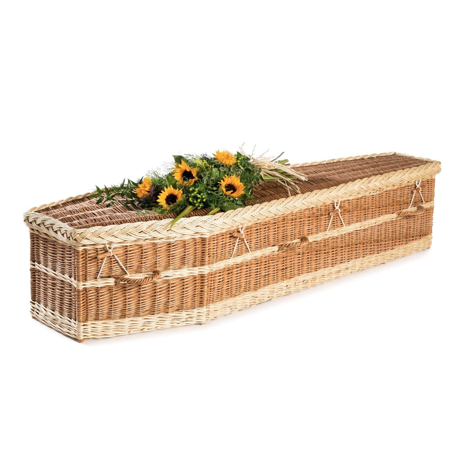 A willow coffin topped with sunflowers