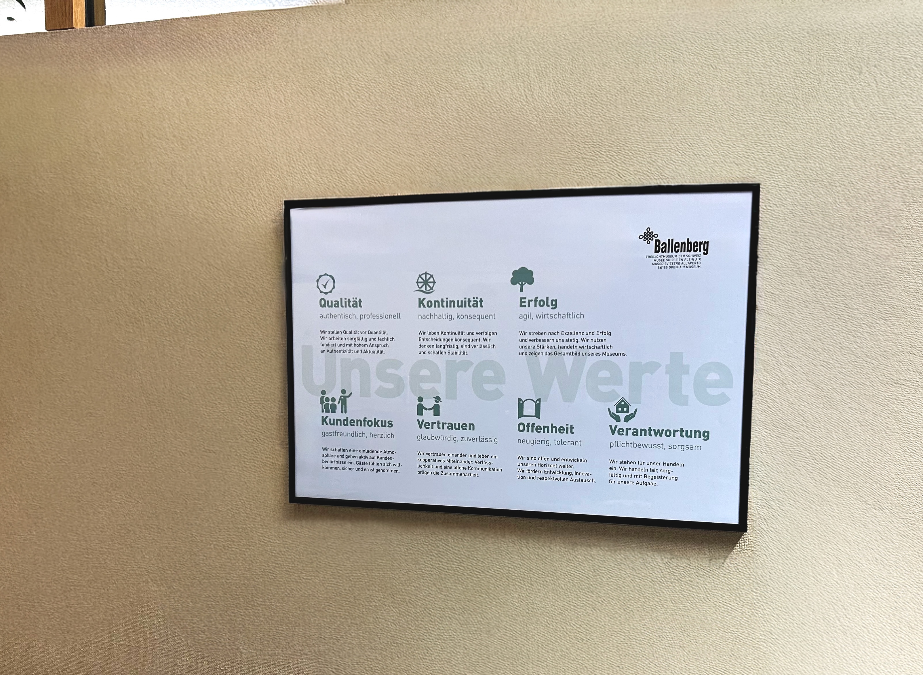 Ballenberg Werteplakat Querformat gerahmt an Bürowand, Einsatz im Arbeitsalltag