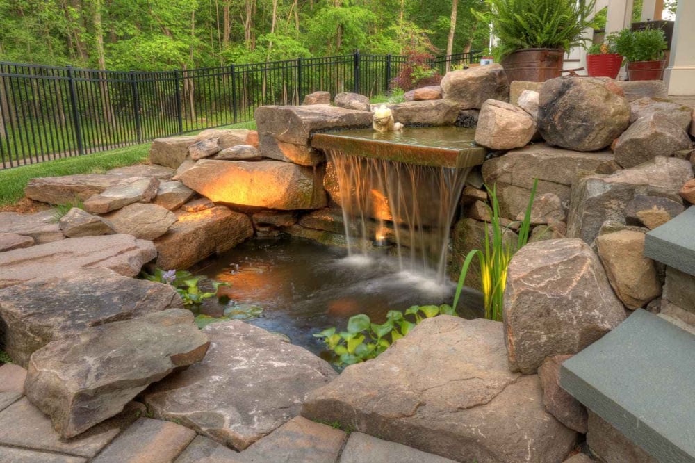 Waterfall with stone surround in backyard patio