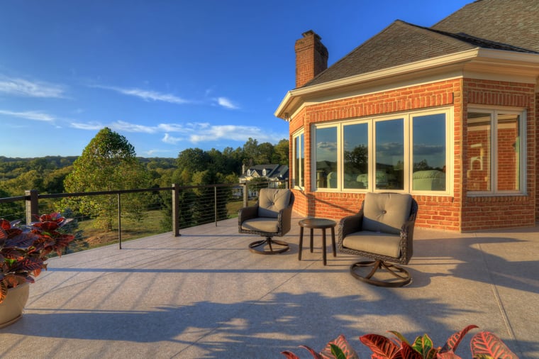 Raised deck view with two chairs facing backyard on sunny day