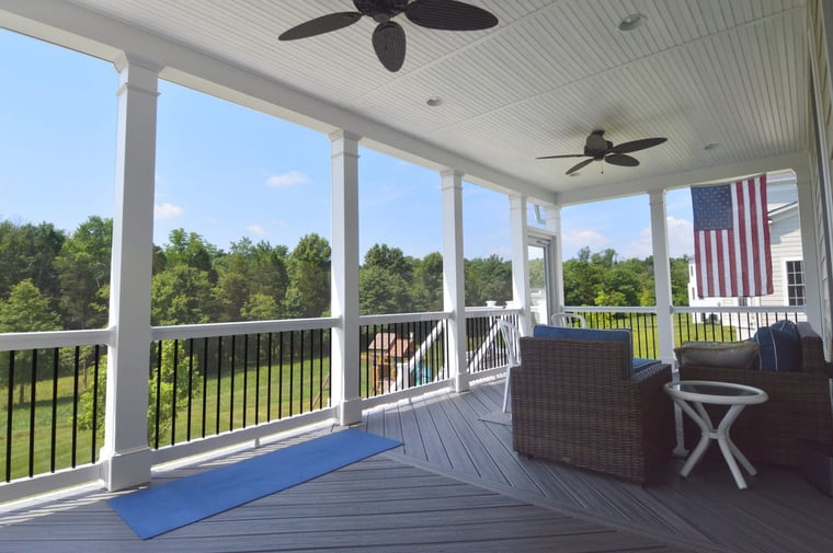 White PVC porch columns with chevron pattern decking