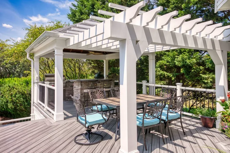 White louvred Struxure pergola on deck with covered outdoor kitchen by Deckscapes of Virginia