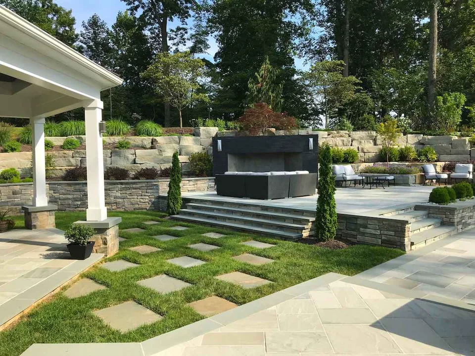 Fireplace and retaining wall on patio with stone walkway
