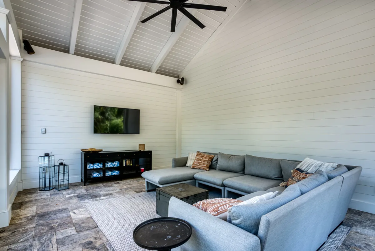 Pool house interior with ceiling fan and TV by Deckscapes of VA