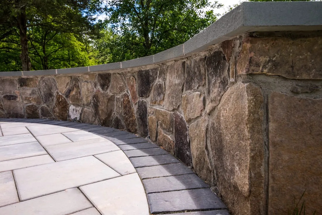 Curved stone patio seating wall by Deckscapes of Virginia